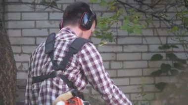 Bahçede çim biçen bir bahçıvan. Benzin fırçası makasıyla çim biçen adam. Benzin budama makinesiyle çim biçme işlemi. Çim biçme işi. Kesici, bahçecilik konsepti. Çim biçme makinesi, millet.