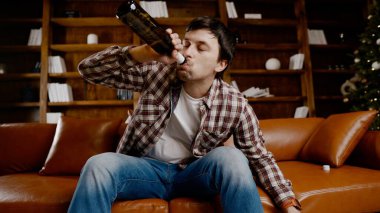 Genç erkek alkoliğin tıbbi ve psikolojik yardıma ihtiyacı var. Adam alkol bağımlısı ve Noel ve yeni yıl arifesinde evde kanepede kalamıyor. Sarhoş adam Noel ağacının yanındaki şişeden şarap içiyor..