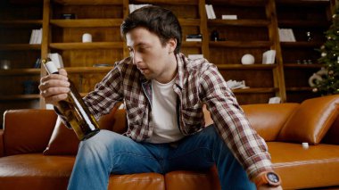 Genç erkek alkoliğin tıbbi ve psikolojik yardıma ihtiyacı var. Adam alkol bağımlısı ve Noel ve yeni yıl arifesinde evde kanepede kalamıyor. Sarhoş adam Noel ağacının yanındaki şişeden şarap içiyor..