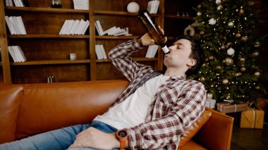 Alkol bağımlılığı, genç yaşta. Beyaz erkek alkolü bırakamıyor, sarhoş yalnız erkek şişeden şarap içiyor. Noel ve Yeni Yıl tatilleri boyunca yalnızlık, depresyon ve alkolizm.