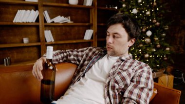 Genç erkek alkoliğin tıbbi ve psikolojik yardıma ihtiyacı var. Adam alkol bağımlısı ve Noel ve yeni yıl arifesinde evde kanepede kalamıyor. Sarhoş adam Noel ağacının yanındaki şişeden şarap içiyor..