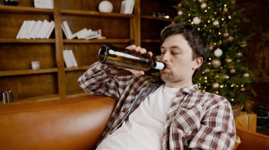 Genç erkek alkoliğin tıbbi ve psikolojik yardıma ihtiyacı var. Adam alkol bağımlısı ve Noel ve yeni yıl arifesinde evde kanepede kalamıyor. Sarhoş adam Noel ağacının yanındaki şişeden şarap içiyor..