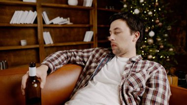 Genç erkek alkoliğin tıbbi ve psikolojik yardıma ihtiyacı var. Adam alkol bağımlısı ve Noel ve yeni yıl arifesinde evde kanepede kalamıyor. Sarhoş adam Noel ağacının yanındaki şişeden şarap içiyor..