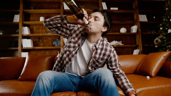 Alkol bağımlılığı, genç yaşta. Beyaz erkek alkolü bırakamıyor, sarhoş yalnız erkek şişeden şarap içiyor. Noel ve Yeni Yıl tatilleri boyunca yalnızlık, depresyon ve alkolizm.