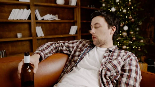 Genç erkek alkoliğin tıbbi ve psikolojik yardıma ihtiyacı var. Adam alkol bağımlısı ve Noel ve yeni yıl arifesinde evde kanepede kalamıyor. Sarhoş adam Noel ağacının yanındaki şişeden şarap içiyor..