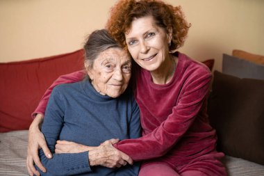 Yaşlı, sevimli, Alzheimer hastası yaşlı bir kadın. Büyük kızı ona sarılıp baktığı zaman çok mutlu ve gülümsüyor. Tema yaşlanma ve ebeveynlik, aile ilişkileri ve en eski sosyal bakım.