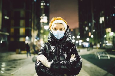 Üst düzey Kafkasyalı kadın, Coronavirüs salgınına karşı kişisel koruyucu ekipman, ellerinde beyaz lateks eldivenler ve tıbbi maske yüz ve bilgi eğitim hikayelerine karşı önem gösteriyor..