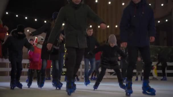 Spend New Year and Christmas holidays actively with families, skating in evening skating rink. Christmas fair and skating rink in Kiev, Ukraine at st. Bank str near president office December 23, 2020 — Stock Video