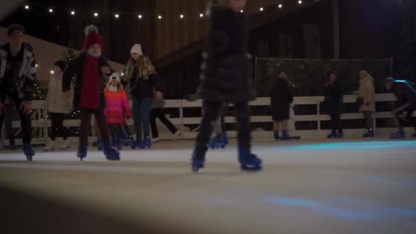 Kerst beurs en schaatsbaan in Kiev, Oekraïne st. Bankova Street in de buurt van het kantoor van de president op 23 december 2020. Stadsijsbaan in de avond met mooie verlichting en veel blije mensen die schaatsen — Stockvideo