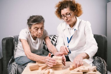 Olgun doktor seansı, huzurevindeki yaşlı hastalar için terapi bunama, alzheimer hastalıkları ve iyileşme enstitüsü için ahşap bloklar katlayarak iyi motor becerileri eğitimi, Jenga oynayarak.