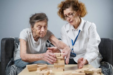 Olgun doktor seansı, huzurevindeki yaşlı hastalar için terapi bunama, alzheimer hastalıkları ve iyileşme enstitüsü için ahşap bloklar katlayarak iyi motor becerileri eğitimi, Jenga oynayarak.