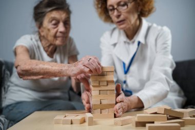 Olgun doktor seansı, huzurevindeki yaşlı hastalar için terapi bunama, alzheimer hastalıkları ve iyileşme enstitüsü için ahşap bloklar katlayarak iyi motor becerileri eğitimi, Jenga oynayarak.