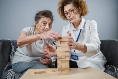 Olgun doktor seansı, huzurevindeki yaşlı hastalar için terapi bunama, alzheimer hastalıkları ve iyileşme enstitüsü için ahşap bloklar katlayarak iyi motor becerileri eğitimi, Jenga oynayarak.