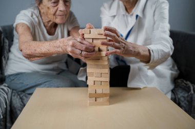 Olgun doktor seansı, huzurevindeki yaşlı hastalar için terapi bunama, alzheimer hastalıkları ve iyileşme enstitüsü için ahşap bloklar katlayarak iyi motor becerileri eğitimi, Jenga oynayarak.