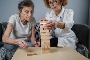 Olgun doktor seansı, huzurevindeki yaşlı hastalar için terapi bunama, alzheimer hastalıkları ve iyileşme enstitüsü için ahşap bloklar katlayarak iyi motor becerileri eğitimi, Jenga oynayarak.