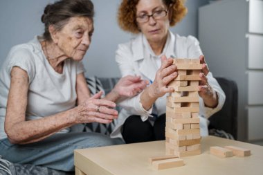 Olgun doktor seansı, huzurevindeki yaşlı hastalar için terapi bunama, alzheimer hastalıkları ve iyileşme enstitüsü için ahşap bloklar katlayarak iyi motor becerileri eğitimi, Jenga oynayarak.