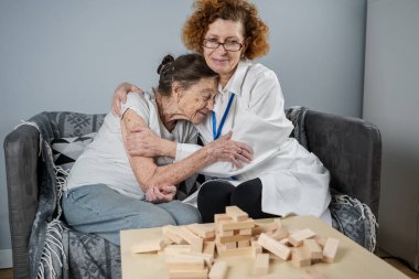 Kıdemli kadın antrenman yetenekleri, tahta bloklar inşa etmek, kule inşa etmek ve yıkılmasına izin vermemeye çalışmak, Jenga oyunu. Eski hasta tıkanıklığı kaldırır, en üstte yer alır, terapi sırasında doktorlara destek olur..