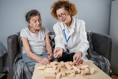 Olgun doktor seansı, huzurevindeki yaşlı hastalar için terapi bunama, alzheimer hastalıkları ve iyileşme enstitüsü için ahşap bloklar katlayarak iyi motor becerileri eğitimi, Jenga oynayarak.