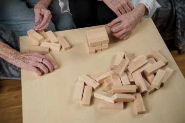 Kıdemli kadın antrenman yetenekleri, tahta bloklar inşa etmek, kule inşa etmek ve yıkılmasına izin vermemeye çalışmak, Jenga oyunu. Eski hasta tıkanıklığı kaldırır, en üstte yer alır, terapi sırasında doktorlara destek olur..