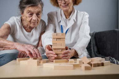 Olgun doktor seansı, huzurevindeki yaşlı hastalar için terapi bunama, alzheimer hastalıkları ve iyileşme enstitüsü için ahşap bloklar katlayarak iyi motor becerileri eğitimi, Jenga oynayarak.