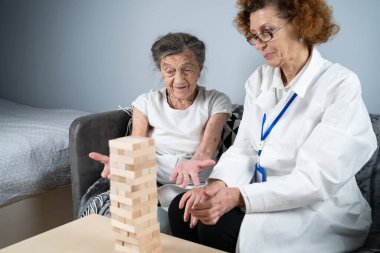 Olgun doktor seansı, huzurevindeki yaşlı hastalar için terapi bunama, alzheimer hastalıkları ve iyileşme enstitüsü için ahşap bloklar katlayarak iyi motor becerileri eğitimi, Jenga oynayarak.