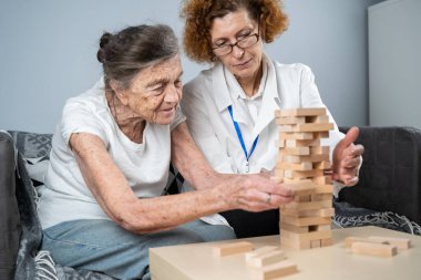 Olgun doktor seansı, huzurevindeki yaşlı hastalar için terapi bunama, alzheimer hastalıkları ve iyileşme enstitüsü için ahşap bloklar katlayarak iyi motor becerileri eğitimi, Jenga oynayarak.