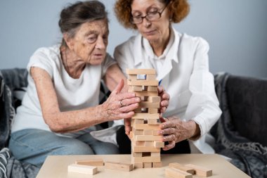 Olgun doktor seansı, huzurevindeki yaşlı hastalar için terapi bunama, alzheimer hastalıkları ve iyileşme enstitüsü için ahşap bloklar katlayarak iyi motor becerileri eğitimi, Jenga oynayarak.