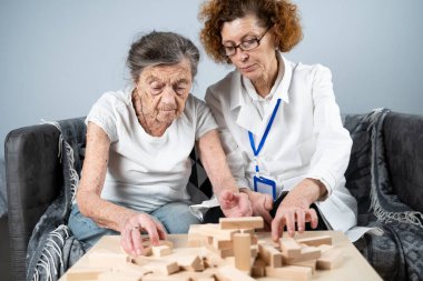 Olgun doktor seansı, huzurevindeki yaşlı hastalar için terapi bunama, alzheimer hastalıkları ve iyileşme enstitüsü için ahşap bloklar katlayarak iyi motor becerileri eğitimi, Jenga oynayarak.