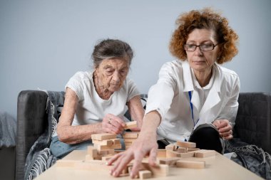Kıdemli kadın antrenman yetenekleri, tahta bloklar inşa etmek, kule inşa etmek ve yıkılmasına izin vermemeye çalışmak, Jenga oyunu. Eski hasta tıkanıklığı kaldırır, en üstte yer alır, terapi sırasında doktorlara destek olur..