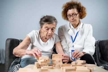 Olgun doktor seansı, huzurevindeki yaşlı hastalar için terapi bunama, alzheimer hastalıkları ve iyileşme enstitüsü için ahşap bloklar katlayarak iyi motor becerileri eğitimi, Jenga oynayarak.