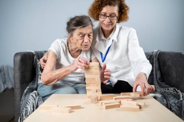 Olgun doktor seansı, huzurevindeki yaşlı hastalar için terapi bunama, alzheimer hastalıkları ve iyileşme enstitüsü için ahşap bloklar katlayarak iyi motor becerileri eğitimi, Jenga oynayarak.