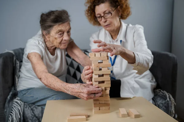 Starsza Kobieta Ćwiczyć Umiejętności Budować Drewniane Bloki Budować Wieżę Starać — Zdjęcie stockowe