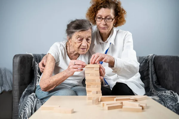 Mujer Mayor Jugando Jenga Construye Una Torre Bloques Médico Anciano —  Fotos de Stock