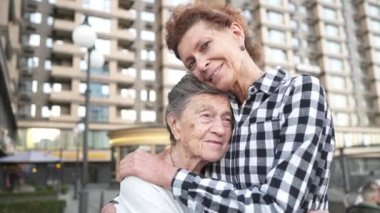 Beyaz, üst düzey ve yaşlı kadınlar şehirde anne ve kızına sevgi, ilgi, yardım, destek ve sempati ile sarılıyorlar. Farklı kuşaklardan dürüst bir aile şakalaşıyor, eğleniyor.