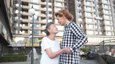 Neşeli bir an. Aile bağlantısı. Yaşlı bakımı. Kızı büyük anneye sarılıyor. Sarılma konsepti. Gülümseyen kadın ve yaşlı anne kucaklaşıp birlikte eğleniyorlar. Mutlu kadın iki kuşak aile aşkı