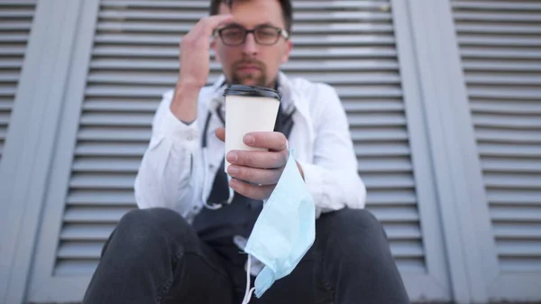 Primer Plano Mano Con Taza Café Máscara Médica Protectora Cansado —  Fotos de Stock