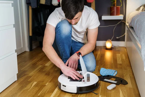 Hombre Joven Caucásico Haciendo Mantenimiento Aspiradora Robot Blanco Aspiradora Moderna — Foto de Stock