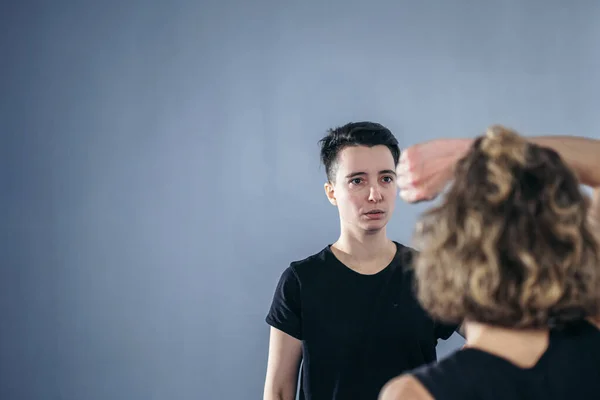 Coach teaches athlete to hit kick. Strong female martial arts athletes in their taekwon-do training. Two young women instructor and student practicing basic self defense skills at gym.