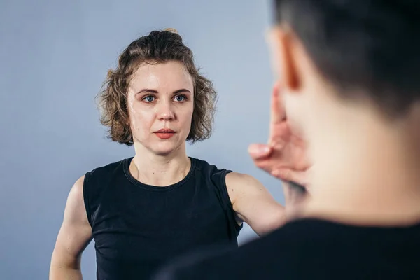 Coach teaches athlete to hit kick. Strong female martial arts athletes in their taekwon-do training. Two young women instructor and student practicing basic self defense skills at gym.