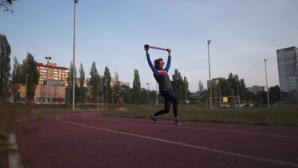 Femme âgée s'étirant avant la marche nordique avec des bâtons de randonnée sur la piste de course du stade. Femme plus âgée sportive échauffement bâtons d'entraînement. Style de vie actif et bien-être. Divers exercices pôles nordiques — Video