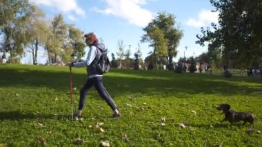 Beyaz, zayıf, yaşlı bir kadın. Aktif, İskandinavyalı. Şehir parkında çubuklar ve dachshund köpeğiyle geziyor. Aktif son sınıf öğrencisi kadın evcil hayvanla dışarıda sırıklarla yürüyor.
