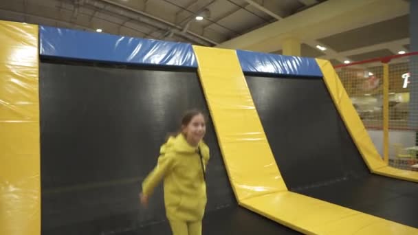 Happy tersenyum 11 tahun anak-anak berusia melompat di atas trampolin dalam ruangan di pusat hiburan. Anak-anak aktif waktu luang, melompat dan bermain trampolin di pusat olahraga. Taman Hiburan. Aktivitas olahraga — Stok Video
