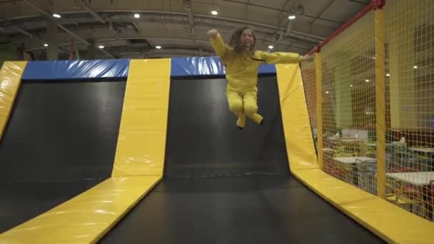 Leuke tweeling broer en zus springen en stuiteren op indoor trampoline samen bij het doorbrengen van tijd in kinderen play center. Sport en amusement concept. Sport en hobby 's voor kinderen — Stockvideo