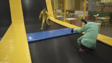 Çocuklar boş vakitlerinde aktiftir. Spor merkezinde hafta sonu akrobasi ve trambolin. Beden eğitimi. Çocuklar trambolinde eğleniyor eğlence merkezinde, çocuklukta ve sportif yaşam tarzında