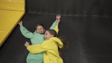 Aktif boş zaman. Çocuklar trambolinde eğleniyor eğlence merkezinde, çocuklukta ve sportif yaşam tarzında. Çocuklar için eğlence merkezindeki kız ve erkek. Erkek ve kız kardeş trambolinlere dalar.