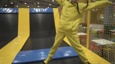 Çocuk oyun merkezinde zaman geçirirken şirin ikiz kardeşler trambolinde zıplıyor ve zıplıyorlar. Spor ve eğlence konsepti. Çocuk sporları ve hobileri