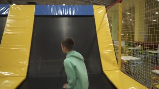 Aktywny wypoczynek dzieci. Weekend sportowy w centrum sportowym akrobacji i trampoliny. Wychowanie fizyczne. Dzieci bawiące się na trampolinie w centrum rozrywki, dzieciństwie i sportowym stylu życia — Wideo stockowe