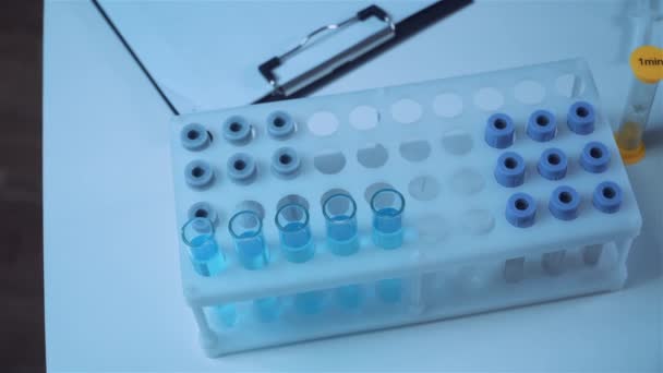 Close-up of scientists hand in blue latex gloves examines samples chemical liquid in test tube in science laboratory. Research and development. Lab technician examines proof experimental substance — Stock Video