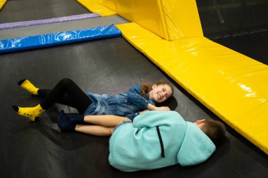 Eğlence merkezinde trambolinde zıplayan 11 yaşındaki mutlu çocuklar. Aktif çocuk eğlencesi, spor merkezinde trambolinde zıplamak ve oynamak. Eğlence parkı. Spor etkinliği.