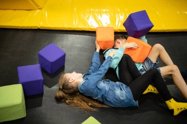 Eğlence merkezinde trambolinde zıplayan 11 yaşındaki mutlu çocuklar. Aktif çocuk eğlencesi, spor merkezinde trambolinde zıplamak ve oynamak. Eğlence parkı. Spor etkinliği.